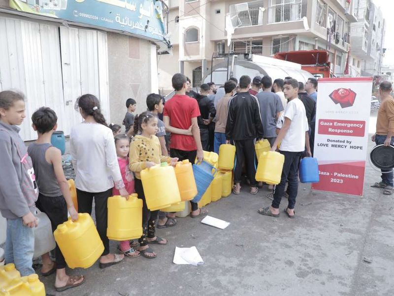 People queuing for clean water delivered in Gaza in 2023