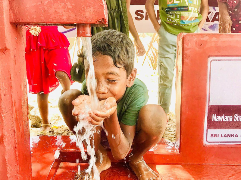 A boy drinking from a well in Sri Lanka