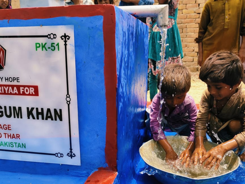 Children washing their hands at a new hand pump in Pakistan, plaque PK-51