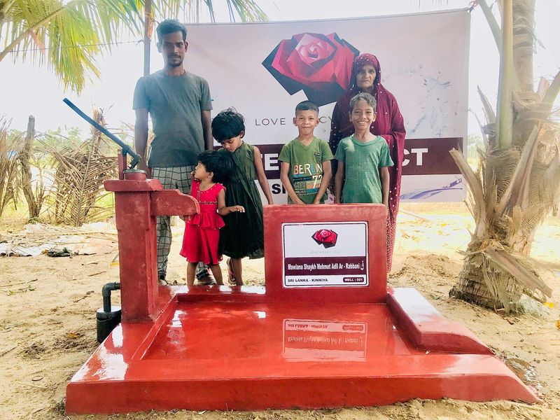 A family beside a new well in Kinniya, Sri Lanka